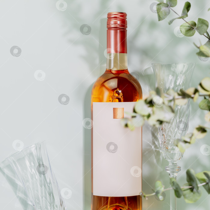 Скачать Бутылка натурального розового вина с бокалами на синем фоне фотосток Ozero