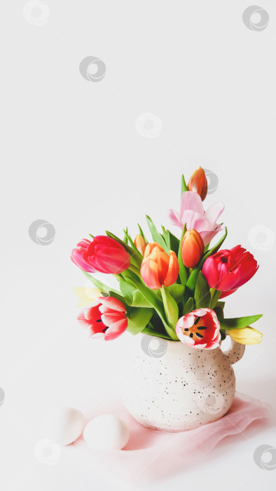 Скачать Пасхальный натюрморт с разноцветными тюльпанами в кувшине и белыми яйцами фотосток Ozero