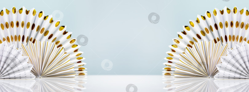 Скачать Белый стол с декоративными бумажными веерами на синем фоне фотосток Ozero