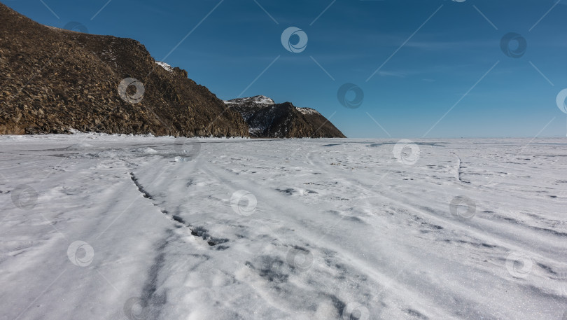 Скачать Гладкая поверхность замерзшего озера. Снежные узоры на льду.  Байкал. Зимний день. фотосток Ozero