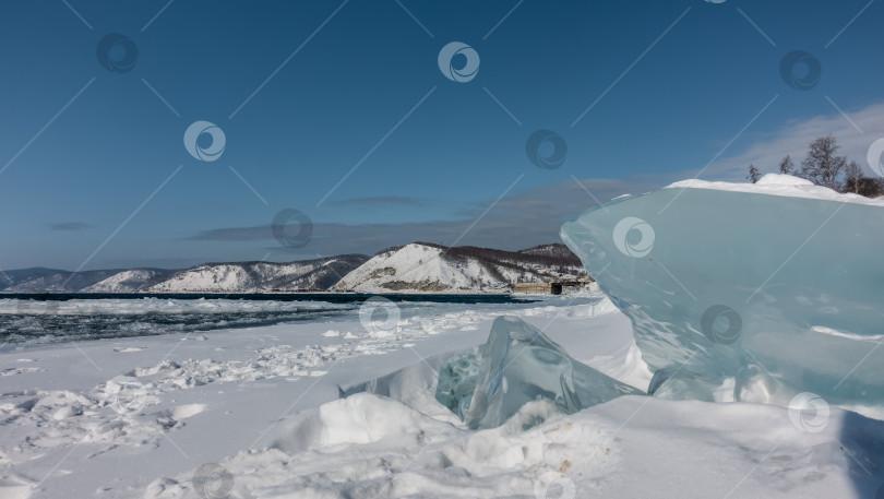 Скачать На берегу незамерзающей реки лежат сугробы и глыбы льда. фотосток Ozero