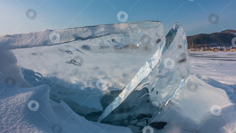 Скачать Прозрачные льдины на замерзшем озере на фоне голубого неба. фотосток Ozero