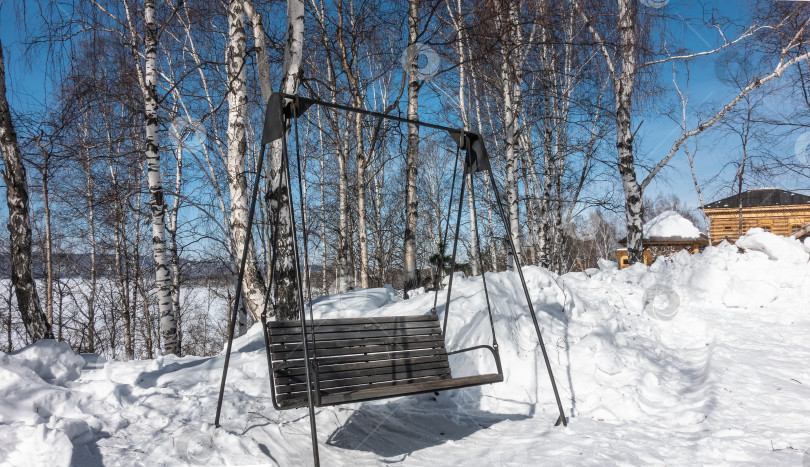 Скачать Качели - скамья из неокрашенных досок, подвешенная на металлических опорах. фотосток Ozero