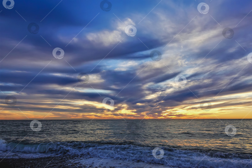 Скачать Красочный закат над Черным морем. В голубом небе плывут пурпурные облака. Оранжевое зарево над горизонтом. фотосток Ozero