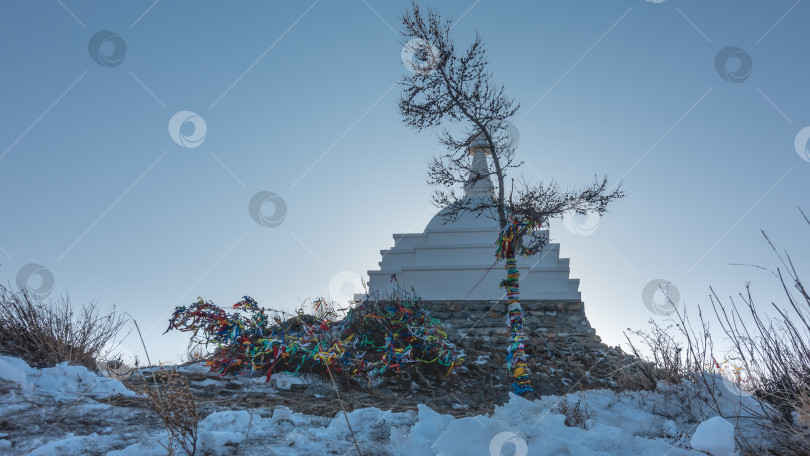 Скачать Ритуальная белая ступа на холме, на фоне голубого неба. Сибирь фотосток Ozero