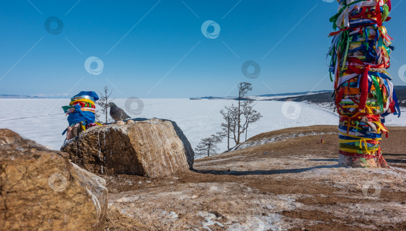 Скачать На холме стоят ритуальные столбы, перевязанные разноцветными яркими лентами. фотосток Ozero