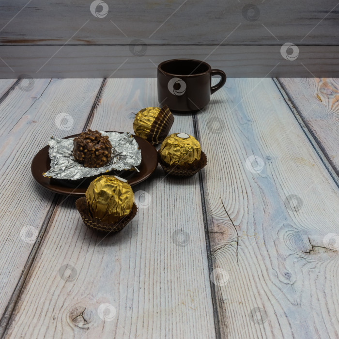 Скачать На деревянном столе стоит коричневое фарфоровое блюдце с раскатанным шоколадом. фотосток Ozero