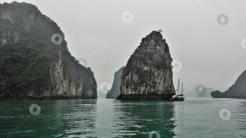 Скачать Причудливые острова с отвесными склонами скрываются в туманной дымке. фотосток Ozero