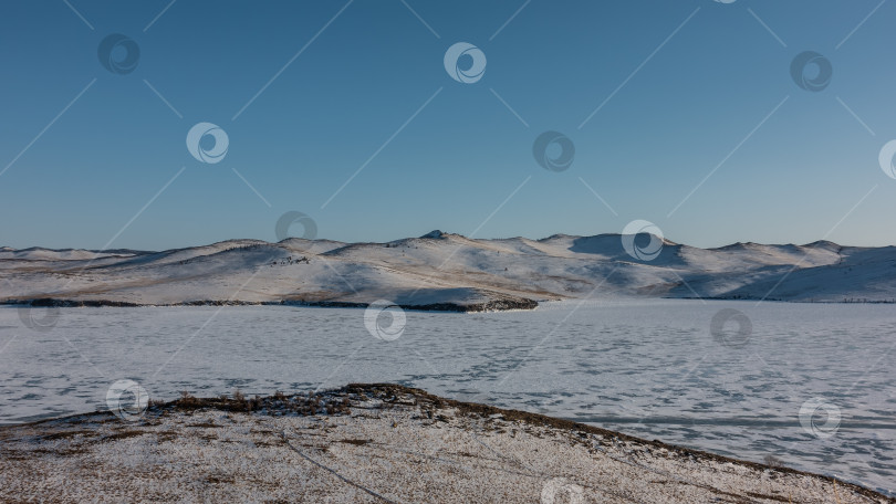 Скачать Замерзшее сибирское озеро среди пустынных берегов. ОБайкал фотосток Ozero