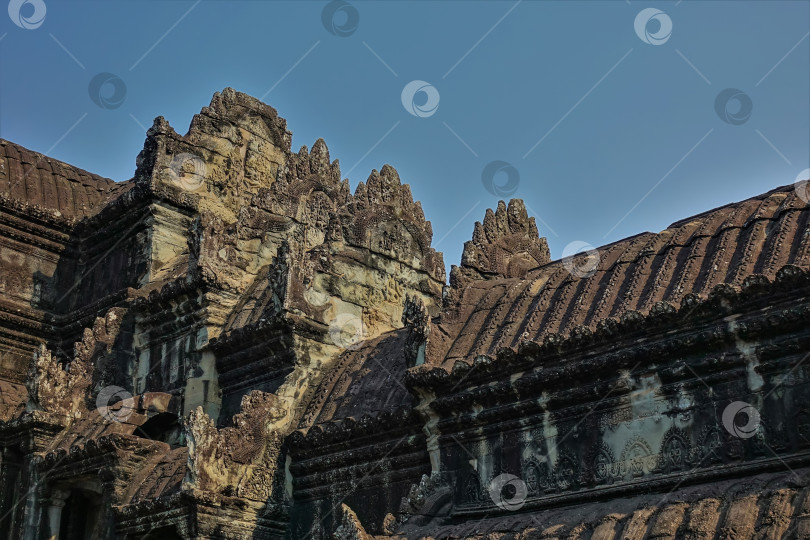 Скачать Фрагмент древнего храма в знаменитом Ангкоре на фоне голубого неба. фотосток Ozero