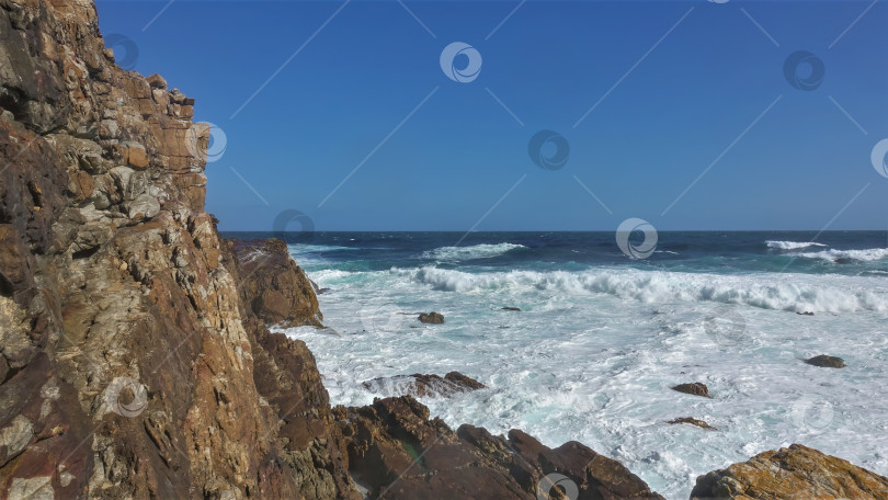 Скачать Бирюзовые волны Атлантического океана разбиваются о крутые прибрежные скалы. фотосток Ozero