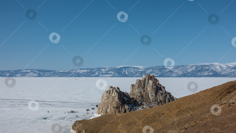 Скачать Необычная двуглавая гора, лишенная растительности, возвышается над замерзшим озером. фотосток Ozero