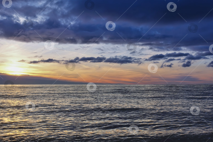 Скачать Закат над морем. Над водой висят темно-синие облака. фотосток Ozero