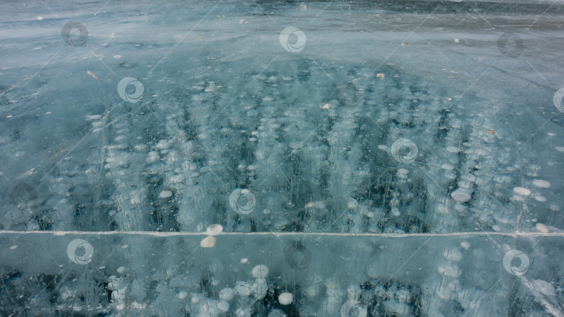 Скачать Бирюзовый прозрачный лед крупным планом.  На поверхности видны трещины фотосток Ozero