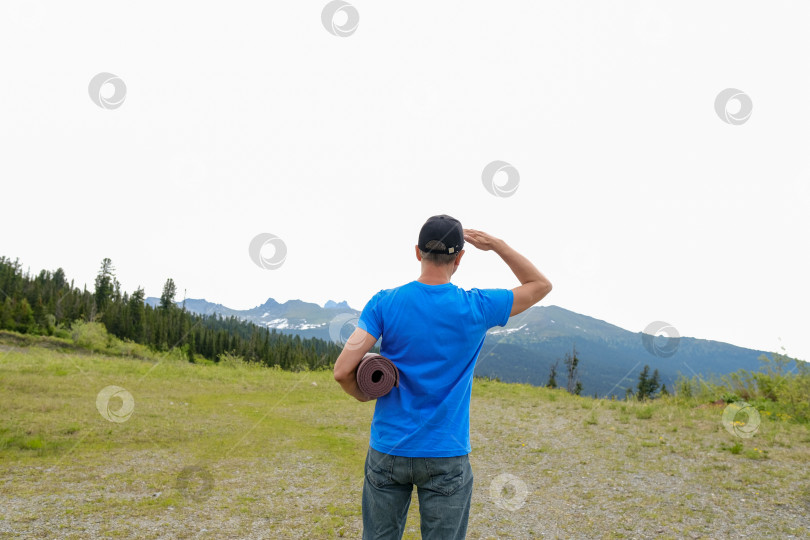 Скачать Мужчины стоят в стороне с ковриком для йоги на фоне горного пейзажа. Йога на открытом воздухе в горах фотосток Ozero