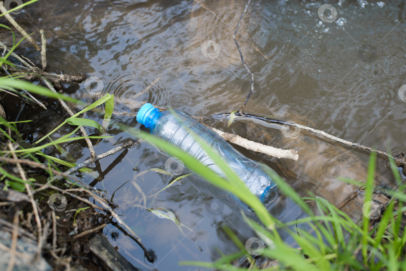 Скачать Пластиковая бутылка, плавающая в воде на природе, вид сверху. Выбрасывайте пластиковый мусор в ручей, озеро или реку на открытом воздухе. Загрязнение природы, концепция экоклогии фотосток Ozero