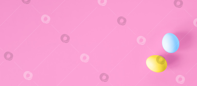 Скачать Пасхальный баннер. Два разноцветных яйца, лежащих ровным слоем на розовом фоне. Праздничный фон, копировальное пространство. Концепция счастливой Пасхи фотосток Ozero