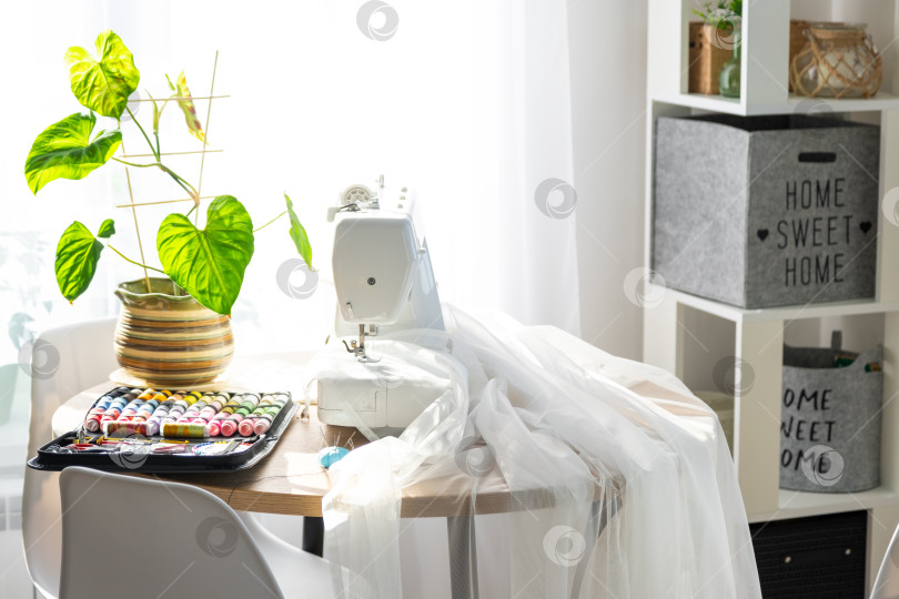 Скачать Швейная машинка на круглом столе в белом интерьере дома фотосток Ozero