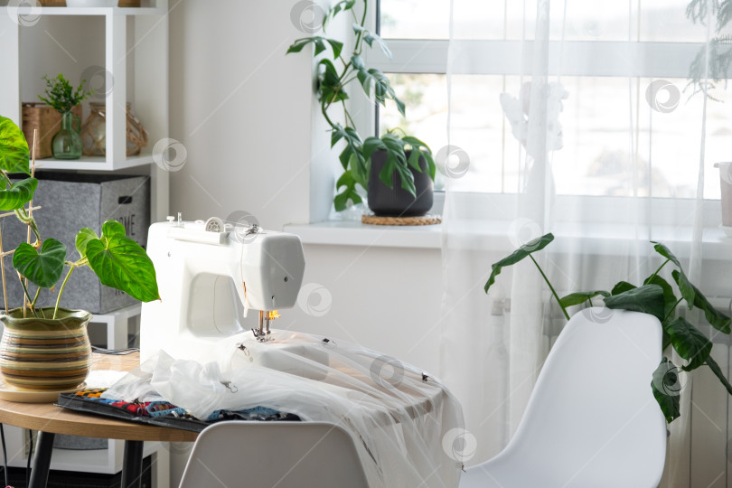 Скачать Швейная машинка на круглом столе в белом интерьере дома фотосток Ozero