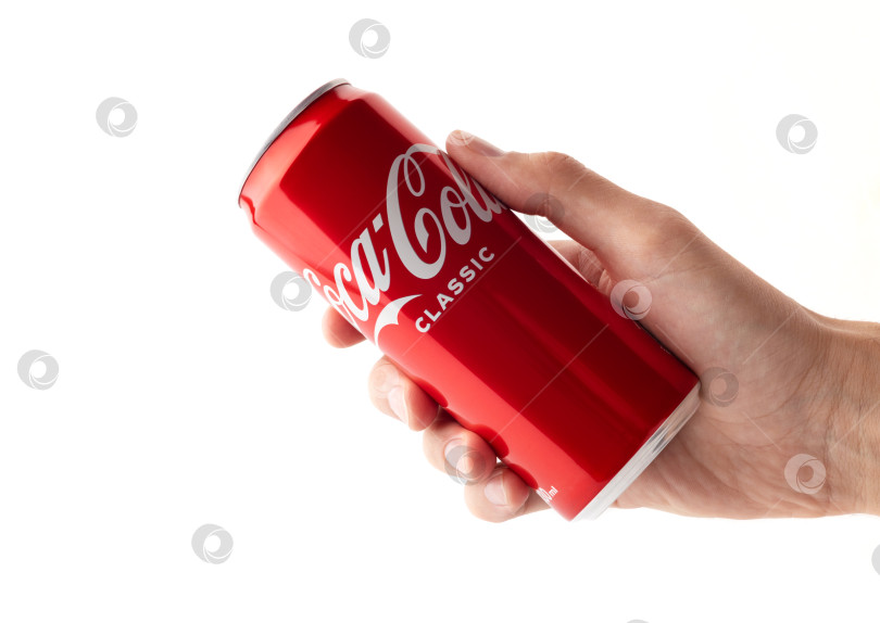 Скачать БАТУМИ, ГРУЗИЯ, 15.03.2023: Холодная банка coca-cola в руке на белом фоне. фотосток Ozero