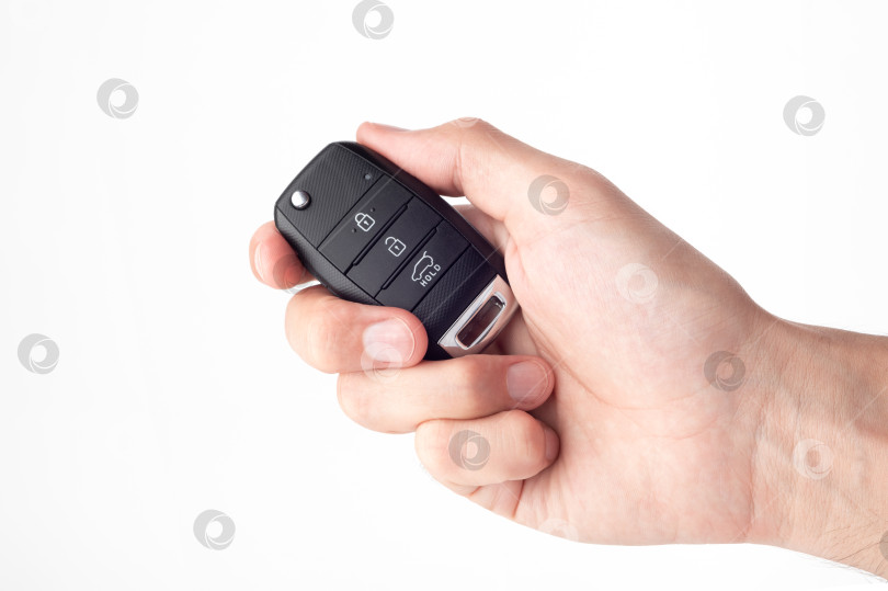 Скачать Мужская рука держит ключи от машины, выделенные крупным планом на белом фоне. фотосток Ozero