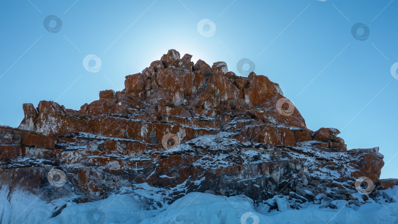 Скачать Красно-коричневая гранитная скала на фоне голубого неба. фотосток Ozero