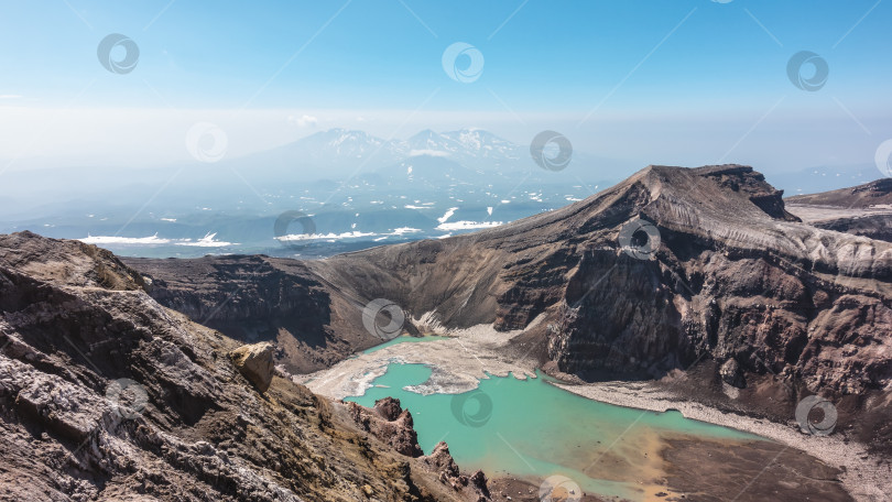 Скачать Кислотное озеро в кратере потухшего вулкана. Бирюзовая вода, растаявший снег на берегах фотосток Ozero