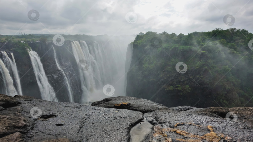 Скачать Мощные потоки водопада Виктория спускаются с края ущелья. фотосток Ozero