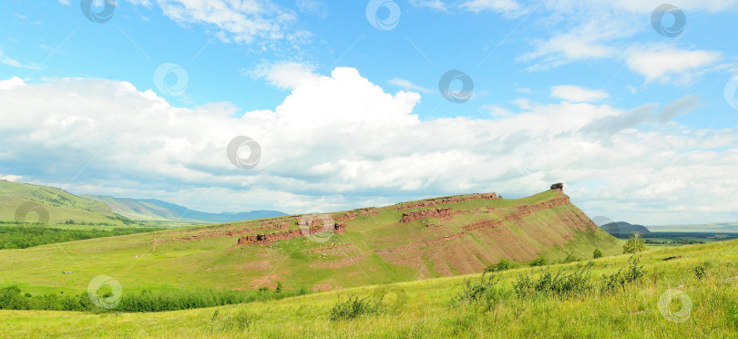 Скачать Панорамный снимок полого холма с остатками древней стены и скальным образованием на вершине. фотосток Ozero