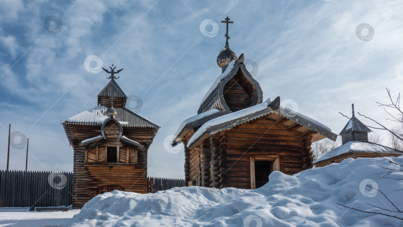 Скачать Старая деревянная часовня и церковь построены из некрашеных бревен. На крыше есть купола и кресты. фотосток Ozero