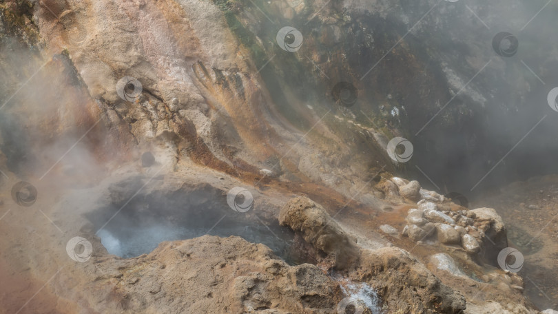 Скачать Гейзер готовится к извержению. Вода бурлит в яме на склоне горы. фотосток Ozero