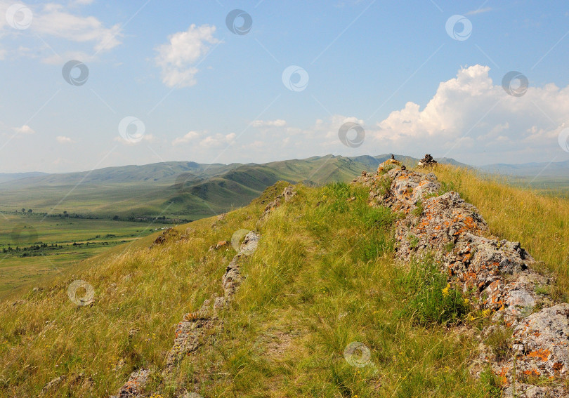 Скачать Вид с вершины горы на холмистую долину в ясный солнечный день. фотосток Ozero