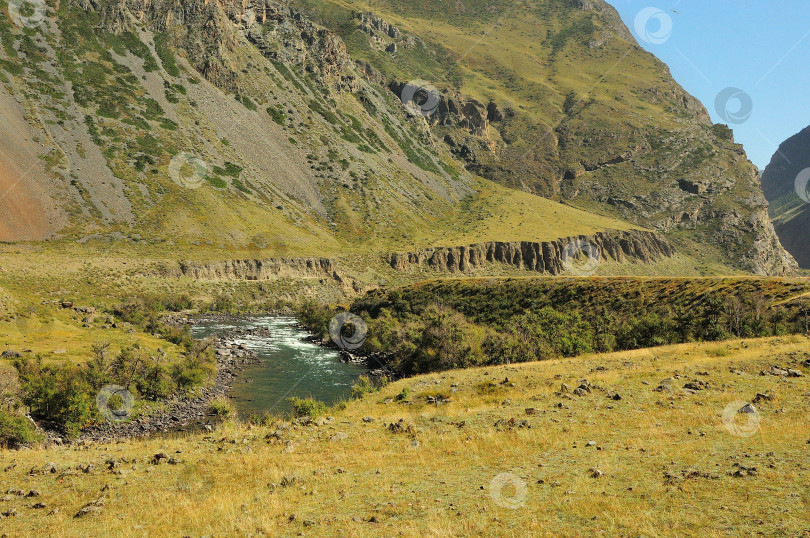 Скачать Извилистое русло красивой бирюзовой горной реки, текущей по дну глубокого каньона, окруженного горами. фотосток Ozero
