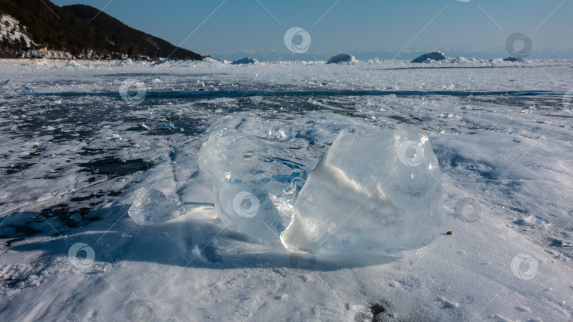 Скачать Осколки прозрачного льда разбросаны по замерзшему озеру. Солнечные блики по краям. фотосток Ozero