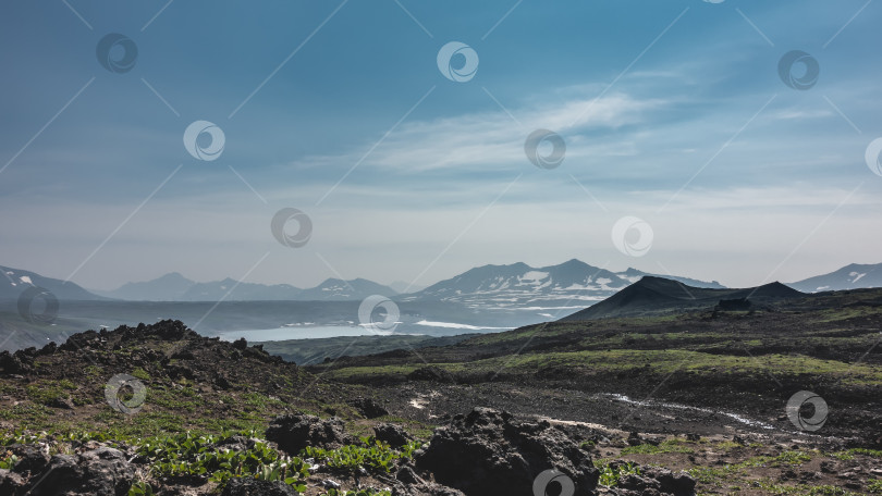 Скачать На склоне горы видна скудная растительность и вулканические породы. фотосток Ozero