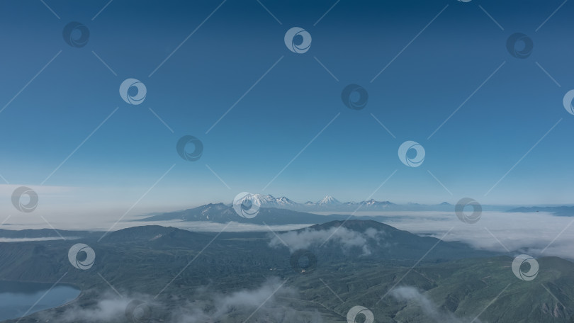 Скачать Камчатский пейзаж, вид с высоты. Облака плывут над зелеными горами и озером. фотосток Ozero