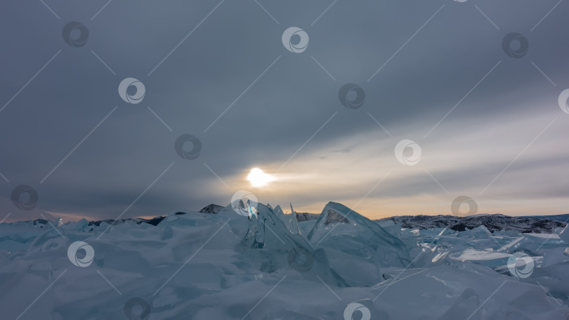 Скачать На замерзшем озере - глыба бирюзовых ледяных торосов. Блики заходящего солнца по краям. фотосток Ozero
