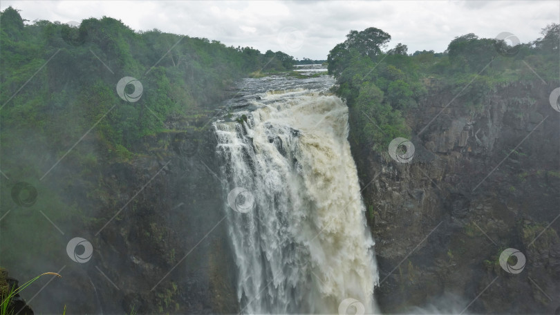 Скачать Река Замбези стекает с края плато в ущелье, образуя водопад Виктория. фотосток Ozero