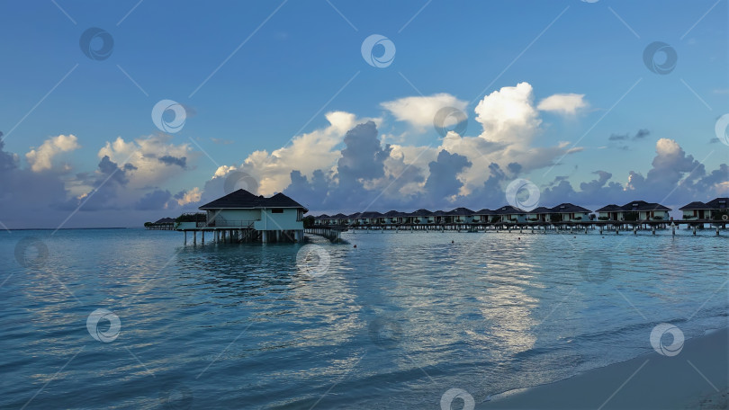 Скачать Ряды вилл на воде выстроились над аквамариновым океаном. фотосток Ozero