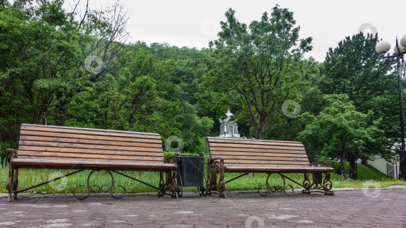 Скачать На мощеной дорожке в парке установлены деревянные скамейки. фотосток Ozero