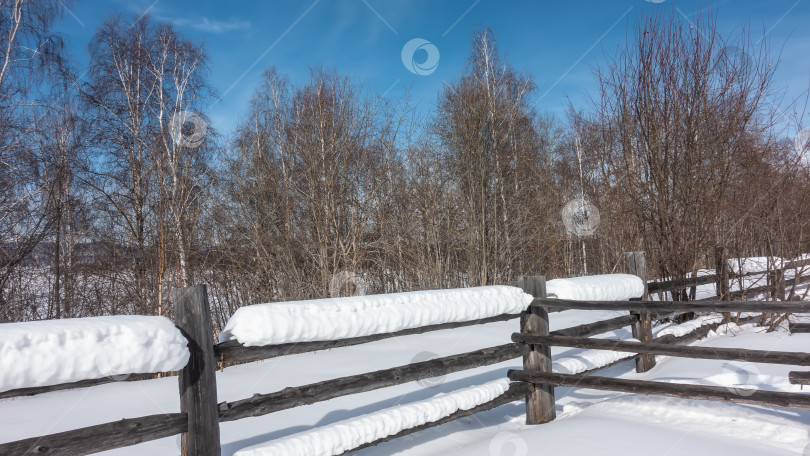 Скачать Толстые слои снега лежат на некрашеном деревянном заборе. фотосток Ozero