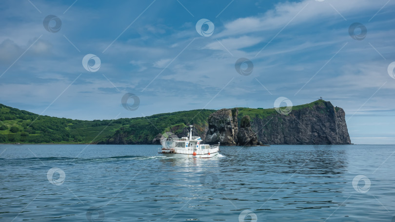 Скачать Белая лодка плывет по голубому океану. Шлейф волн за кормой. фотосток Ozero