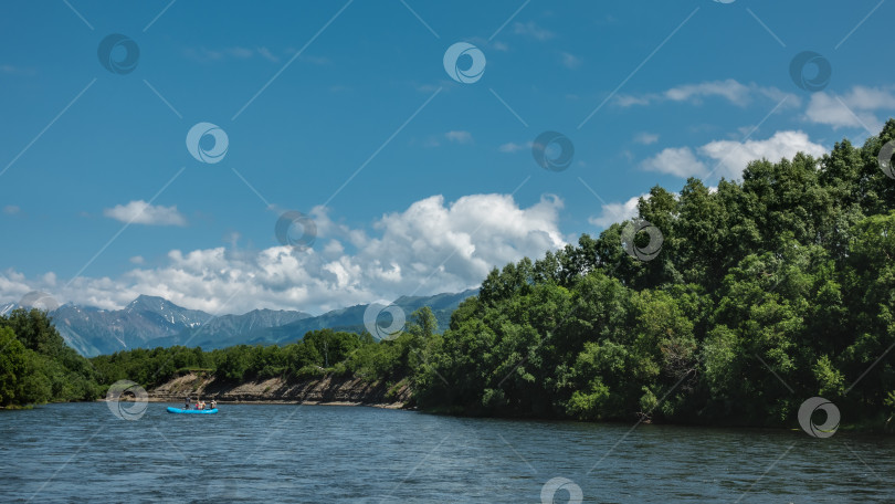 Скачать Надувная лодка с людьми плывет по голубой реке. фотосток Ozero