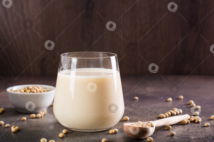 Скачать Соевое молоко в стакане и соевые бобы в миске на столе. Лактоза фотосток Ozero