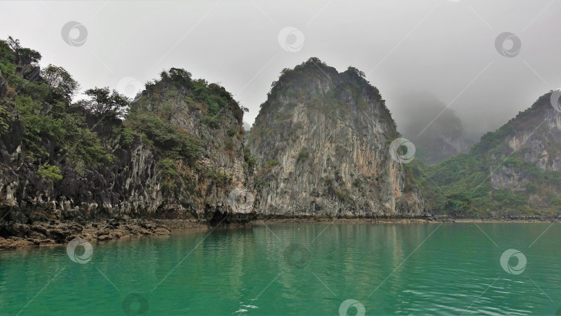 Скачать Острова с крутыми склонами и зеленой растительностью скрываются в тумане. фотосток Ozero