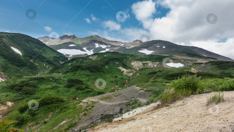 Скачать Склоны гор покрыты зеленой растительностью. В некоторых местах есть растаявший снег. фотосток Ozero