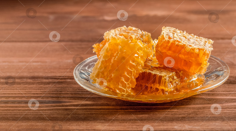 Скачать Соты с пчелиным медом на стеклянной тарелке. Деревянный стол. фотосток Ozero