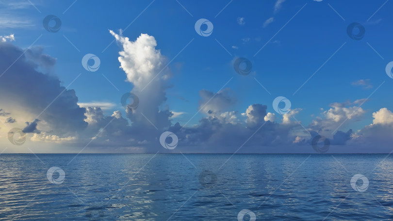 Скачать Легкая рябь на аквамариновом океане. В лазурном небе плывут бело-голубые облака. фотосток Ozero
