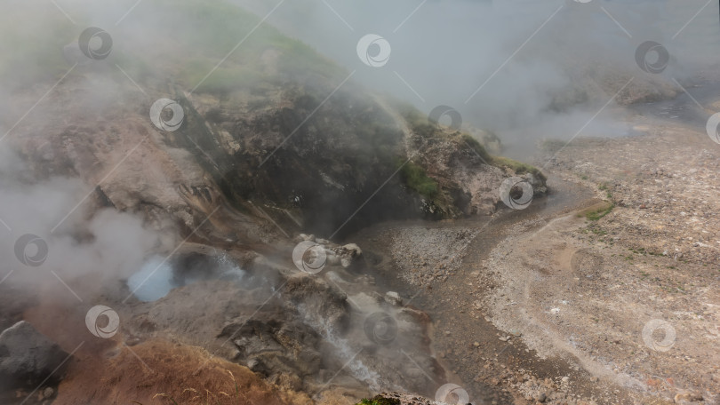 Скачать Вода закипает в отверстии гейзера и стекает в каменистое русло реки. фотосток Ozero