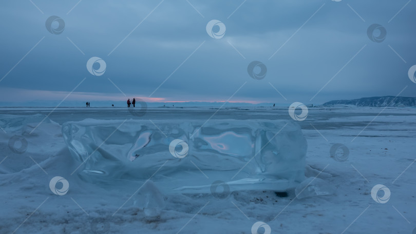 Скачать Блестящая льдина на поверхности замерзшего и покрытого снегом озера. фотосток Ozero